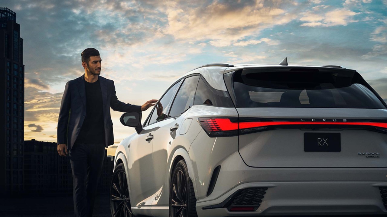 A man walking towards a parked Lexus RX 